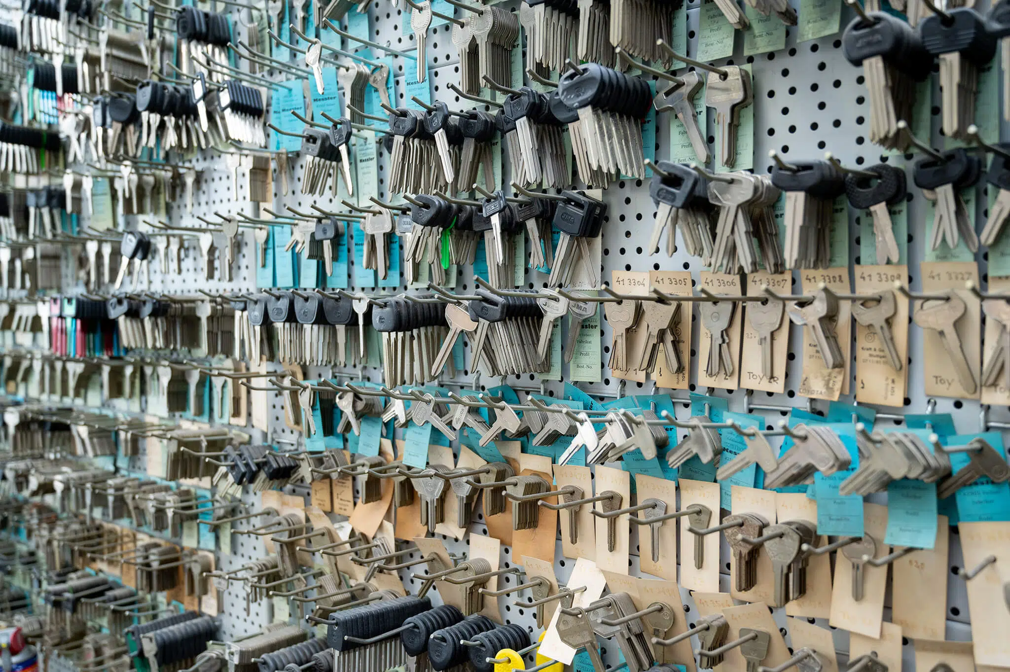Eine Wand voller Schlüssel in verschiedenen Größen und Formen, ordentlich in Regalen und an Haken organisiert.